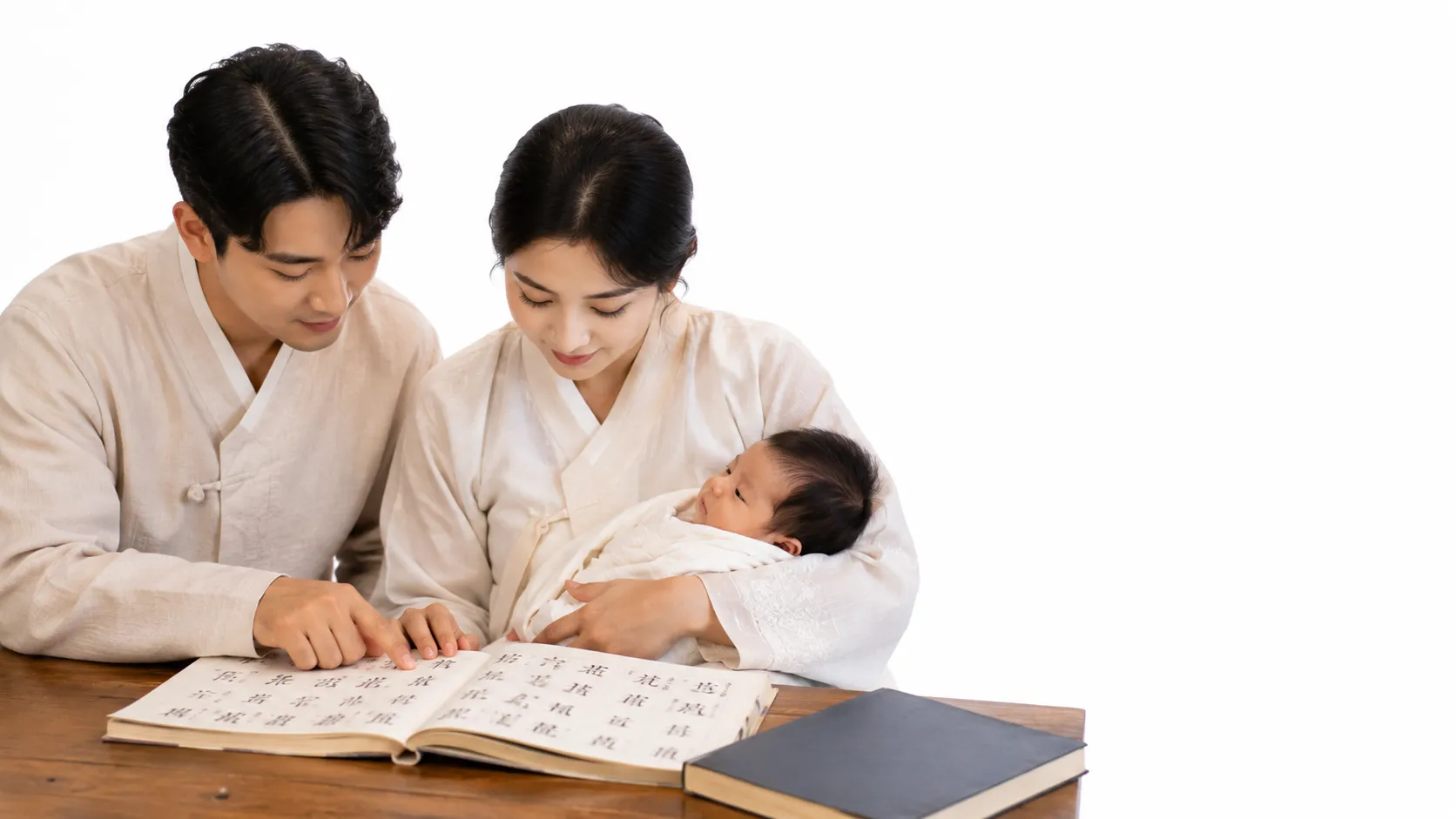 A Korean family with a baby, and a sheet of paper with Korean name characters written on it